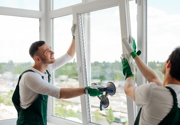 Männer montieren Fenster mit Vierfachverglasung